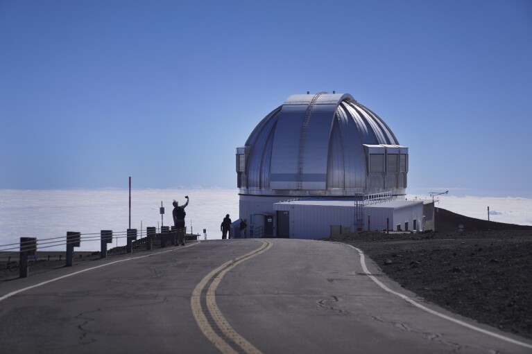 Visitors take photos near an observatory on the summit of Mauna Kea in Hawaii, on Saturday, July 15, 2023. Over the last 50 years, astronomers have mounted 13 giant telescopes on Mauna Kea's summit. In 2009, they proposed an even larger Thirty Meter Telescope, which spurred lawsuits and protests by Native Hawaiian activists. (AP Photo/Jessie Wardarski)
