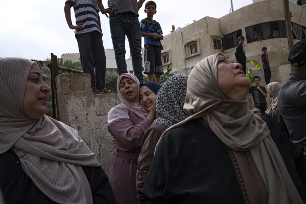 Relatives mourn people killed in an Israeli air strike in Gaza City on Monday, Oct. 9, 2023. (AP Photo/Fatima Shbair)
