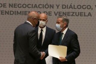 FILE - Venezuelan President of the National Assembly Jorge Rodriguez, left, shakes hands with Venezuelan opposition delegate Gerardo Blyde Perez in Mexico City, Aug. 13, 2021. Venezuela’s government and opposition will resume their dialogue, mediated by Norway, with talks scheduled for Tuesday, Oct. 17,2023 in Barbados, Norway’s embassy in Mexico said on Oct. 16, 2023 in a brief statement. (AP Photo/Marco Ugarte, File)