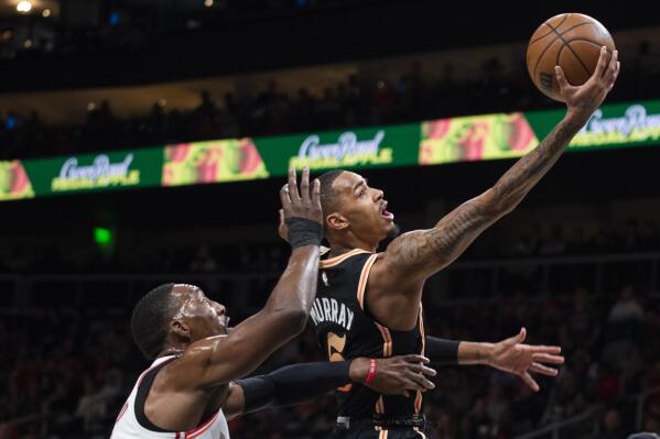 Atlanta Hawks guard Dejounte Murray, right, goes up to score against Miami Heat center Bam Adebayo during the first half of an NBA basketball game, Monday, Jan. 16, 2023, in Atlanta. (AP Photo/Hakim Wright Sr.)