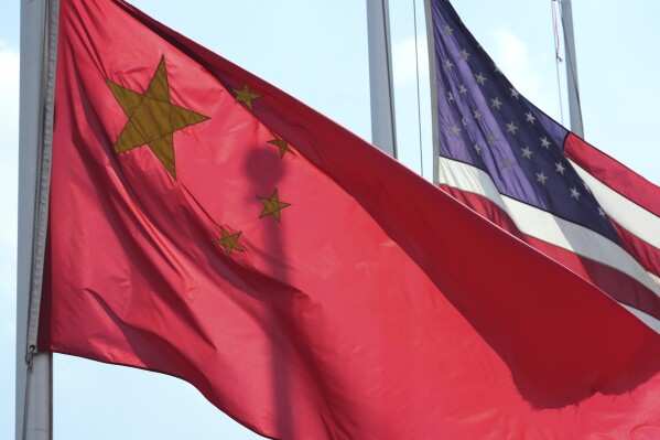 A Chinese and American flag fly outside a Paslin facility Wednesday, April 23, 2025, in Warren, Mich. (AP Photo/Paul Sancya)