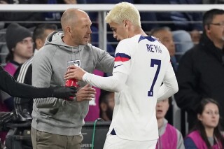 FILE - United States head coach Gregg Berhalter, left, talks to midfielder Gio Reyna (7) during the first half of an international friendly soccer match against Ghana, Tuesday, Oct. 17, 2023, in Nashville, Tenn. Berhalter understands why Reyna may leave Borussia Dortmund during the January transfer window. The 21-year-old midfielder has started just one Bundesliga match this season, playing the first half at Eintracht Frankfurt on Oct. 29. “Any professional who’s competitive wants to be on the field,” Berhalter said Friday, Jan. 19, 2024. (AP Photo/George Walker IV, File)