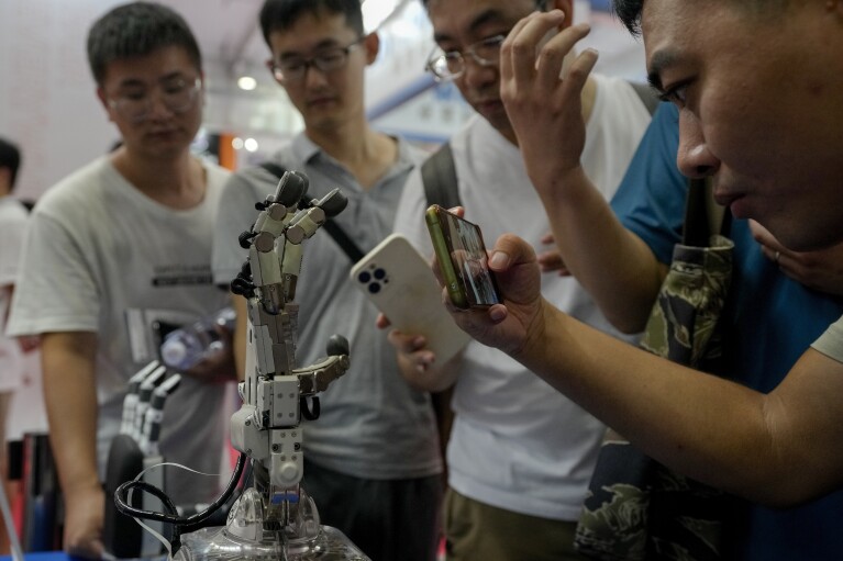 Visitors look at robot palms during the annual World Robot Conference at the Etrong International Exhibition and Convention Center on the outskirts of Beijing, Thursday, Aug. 17, 2023. (AP Photo/Andy Wong)