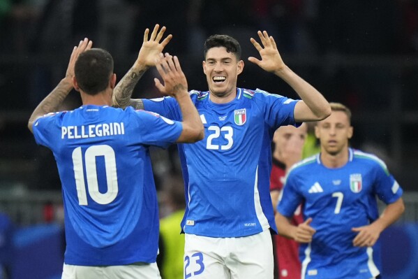 Italy's Alessandro Bastoni, center, celebrates with his teammate Lorenzo Pellegrini after scoring his side's opening goal during a Group B match between Italy and Albania at the Euro 2024 soccer tournament in Dortmund, Germany, Saturday, June 15, 2024. (AP Photo/Alessandra Tarantino)