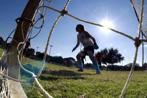 FILE - The goalkeeper guards the net as girls take part in the first day of tryouts for the Fort Walton Beach High School girls' soccer team in Fort Walton Beach, Fla., on Oct. 10, 2012. Questions about female athletes’ menstrual history will no longer appear on the medical forms that Florida high school students have to fill out before participating in sports, though the new form will still ask athletes for their sex assigned at birth, rather than just their sex. The Florida High School Athletic Association axed the questions on Thursday, Feb. 9, 2023, after listening to a flood of complaints contained in letters read aloud during an emergency meeting of the board. (Devon Ravine/Northwest Florida Daily News via AP, File)