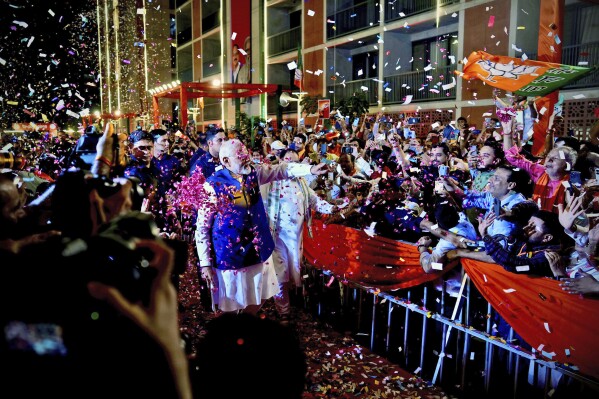 Prime Minister Narendra Modi is greeted by supporters as he arrives at Bharatiya Janata Party (BJP) headquarters in New Delhi, India, Tuesday, June 4, 2024. (AP Photo/Manish Swarup)