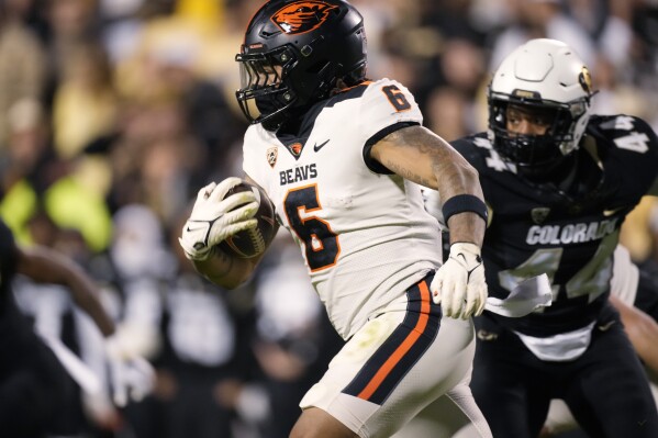 Oregon State running back Damien Martinez runs for a short gain as Colorado linebacker Jordan Domineck pursues during the first half of an NCAA college football game Saturday, Nov. 4, 2023, in Boulder, Colo. (AP Photo/David Zalubowski)