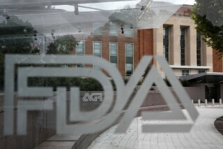 The U.S. Food and Drug Administration building behind FDA logos at a bus stop on the agency's campus in Silver Spring, Md, Thursday, Aug. 2, 2018. (AP Photo/Jacquelyn Martin, File)