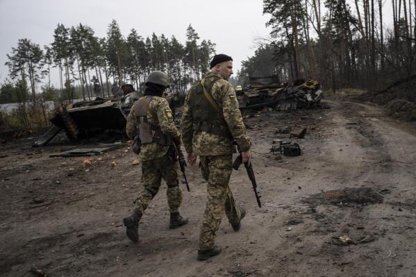 Ukrainian soldiers walk next to destroyed Russian tanks in the outskirts of Kyiv, Ukraine, Thursday, March 31, 2022. Russian forces shelled Kyiv suburbs, two days after the Kremlin announced it would significantly scale back operations near both the capital and the northern city of Chernihiv to “increase mutual trust and create conditions for further negotiations.” (AP Photo/Rodrigo Abd)