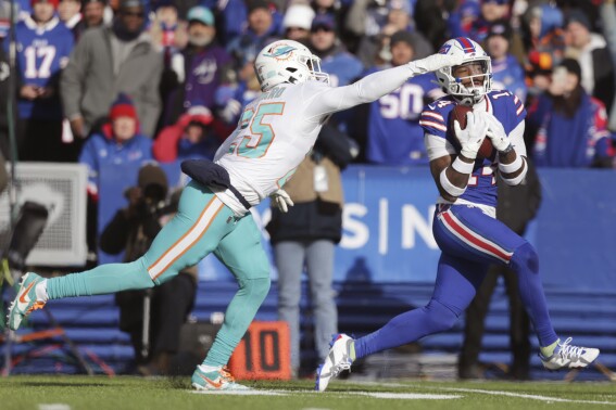 FILE - Buffalo Bills wide receiver Stefon Diggs, right, grabs a pass in front of Miami Dolphins cornerback Xavien Howard (25) during the first half of an NFL wild-card playoff football game Jan. 15, 2023, in Orchard Park, N.Y. Though Bills quarterback Josh Allen blames the media for making too much of Diggs' absence for the start of the Bills mandatory minicamp, the team's premier receiver has yet to publicly address what happened, and address the lingering issues he had carrying over from last season. (AP Photo/Joshua Bessex, File)
