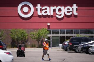 FILE - A worker collects shopping carts in the parking lot of a Target store on June 9, 2021, in Highlands Ranch, Colo. The Associated Press on Thursday, June 1, 2023 reported on posts circulating on social media falsely claiming that a set of images shows satanic-themed apparel being sold at Target stores. (AP Photo/David Zalubowski, File)