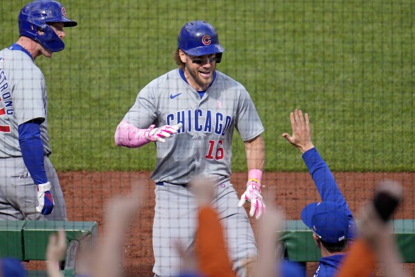 Chicago Cubs' Patrick Wisdom (16) returns to the dugout after hitting a two-run home run off Pittsburgh Pirates relief pitcher Aroldis Chapman during the 10th inning of a baseball game in Pittsburgh, Sunday, May 12, 2024. (AP Photo/Gene J. Puskar)