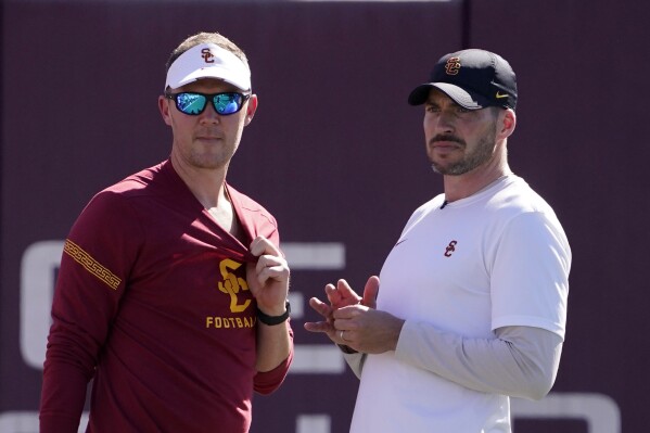 FILE - Southern California head coach Lincoln Riley, left, talks with defensive coordinator Alex Grinch during an NCAA college football practice Thursday, March 24, 2022, in Los Angeles. Grinch says his disappointing tenure as Southern California’s defensive coordinator the last two seasons has given him even more incentive as he begins his new job as Wisconsin’s safeties coach and co-defensive coordinator. (AP Photo/Mark J. Terrill, File)