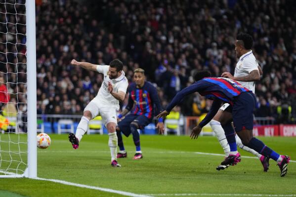 Real Madrid's Eder Militao, top right, scores an own goal past his goalkeeper during the Spanish Copa del Rey semi final, first leg soccer match between Real Madrid and Barcelona at Santiago Bernabeu stadium in Madrid, Spain, Thursday, March 2, 2023. (AP Photo/Manu Fernandez)