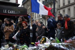 En esta imagen del 16 de noviembre de 2015, personas se reúnen frente a la cafetería Le Carillon, lugar de recientes atentados terroristas, en París. (AP Foto/Jerome Delay)