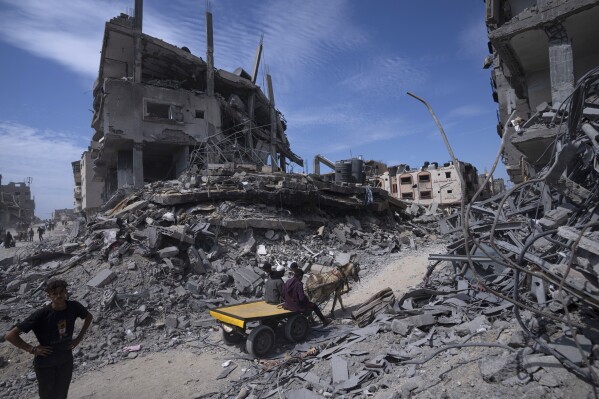 Palestinians salvage what they can from the destruction left by Israeli troops in Khan Younis, southern Gaza Strip, on April 8, 2024. (AP Photo/Fatima Shbair, File)