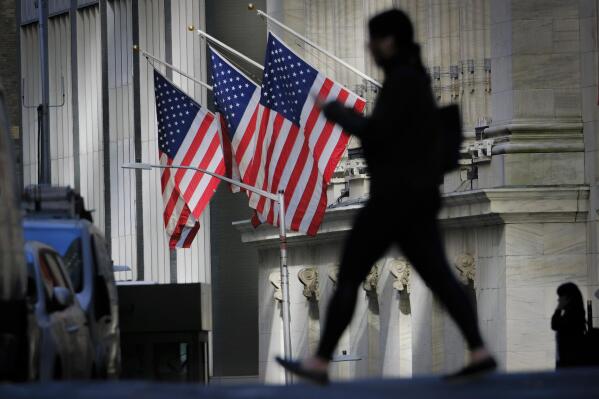 FILE - A pedestrian walks past the New York Stock Exchange in New York City, Thursday, Oct. 27, 2022. The Federal Reserve may reach a turning point this week as it announces what's expected to be another substantial three-quarter-point hike in its key interest rate — its fourth straight. (AP Photo/J. David Ake)