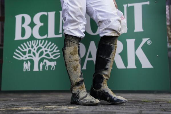 A jockey's boots are caked in mud after an early race ahead of the Belmont Stakes horse race, Saturday, June 10, 2023, at Belmont Park in Elmont, N.Y. (AP Photo/John Minchillo)