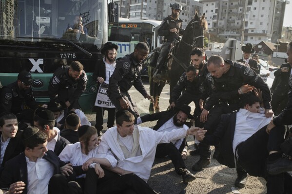 Israeli police officers disperse ultra-Orthodox Jewish men during a protest against army recruitment in Bnei Brak, Israel, Thursday, June 5, 2025. (AP Photo/Leo Correa)