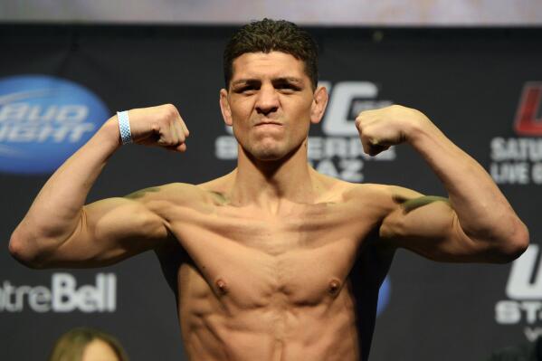 FILE - In this March 15, 2013, file photo, Nick Diaz flexes during the weight-in for UFC 158 in Montreal. Diaz has not competed in mixed martial arts since January 2015, when he lost to Anderson Silva and stepped away from the sport that he admits he does not love. The former Strikeforce welterweight champion is returning to the cage Saturday, Sept. 25, 2021, in a rematch with fellow veteran Robbie Lawler at UFC 266. (Ryan Remiorz/The Canadian Press, File)