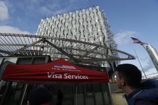 FILE - In this Jan. 16, 2018 file photo, a Visa Services gazebo stands outside the U.S. Embassy in London as visa applicants wait to go inside. A youth soccer club hoping to welcome its new coach from the United Kingdom to Louisiana says it has been caught up in a bureaucratic quagmire for more than a year. The recently filed federal lawsuit that involves a presidential order aimed at curbing travel to stop the spread of COVID-19 names the U.S. Department of State and the U.S. embassy in London as defendants. (AP Photo/Matt Dunham, File)