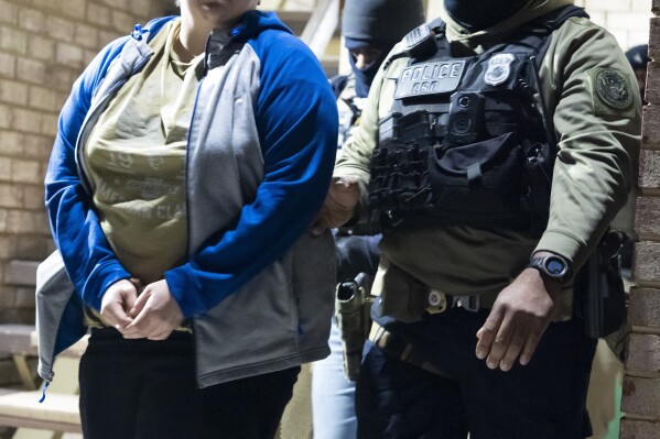 U.S. Immigration and Customs Enforcement officers detain a person, left, Monday, Jan. 27, 2025, in Silver Spring, Md. (AP Photo/Alex Brandon, File)