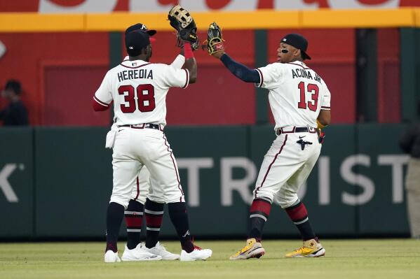 Atlanta Braves right fielder Ronald Acuna Jr. (13), left fielder Guillermo Heredia (38) and a teammate celebrate the team's win over the Oakland Athletics in a baseball game Tuesday, June 7, 2022, in Atlanta. Acuna hit two home runs and Heredia hit one. (AP Photo/John Bazemore)