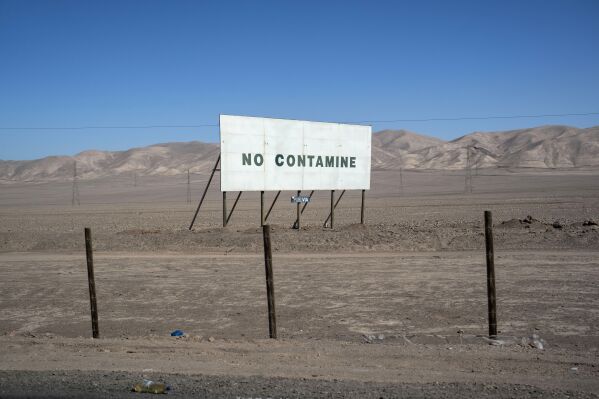 A sign that reads in Spanish, "Do not Pollute," is posted next to the road that connects Antofagasta with San Pedro de Atacama, Chile, Friday, April 19, 2023. Government officials told the AP a new plan would allow them to better regulate water use and distribute wealth beyond “just a small few.” But plans spurred outrage among indigenous communities who said they were once again sidelined by government negotiations with the mines. (AP Photo/Rodrigo Abd)