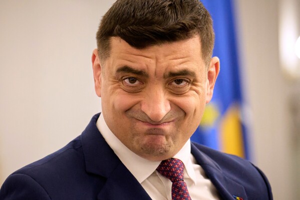 Presidential candidate George Simion waits to address members of the business community at the Chamber of Commerce and Industry of Romania, days ahead of the second round of the presidential election redo in Bucharest, Romania, Tuesday, May 13, 2025. (AP Photo/Vadim Ghirda)