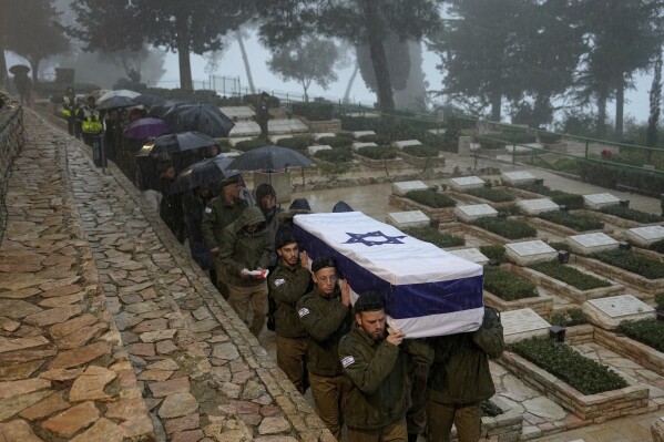 Israeli soldiers carry the flag-draped casket of reservist Elkana Vizel during his funeral at Mt. Herzl military cemetery in Jerusalem, Tuesday, Jan. 23, 2024. (AP Photo/Ohad Zwigenberg)