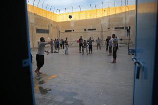 FILE - In this April 3, 2018 file photo, prisoners play volleyball, in a Kurdish-run prison housing former members of the Islamic State group, in Qamishli, north Syria. The Kurdish-led authority in northeast Syria announced Saturday, June 10, 2023 that hundreds of fighters with the Islamic State group held in prisons around the region will be put on trial after their home countries refused to repatriate them. (AP Photo/Hussein Malla, File)