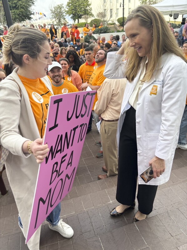 Hannah Miles of Birmingham, left, speaks with Dr. Mamie McLean outside the Alabama Statehouse in Montgomery, Alabama on Feb. 28, 2024. They were among patients and doctors urging Alabama lawmakers to take action to get IVF services in the state. Fertility clinics paused some services in the wake of a state court ruling related to whether embryos are children under a state law. (Kim Chandler/AP)