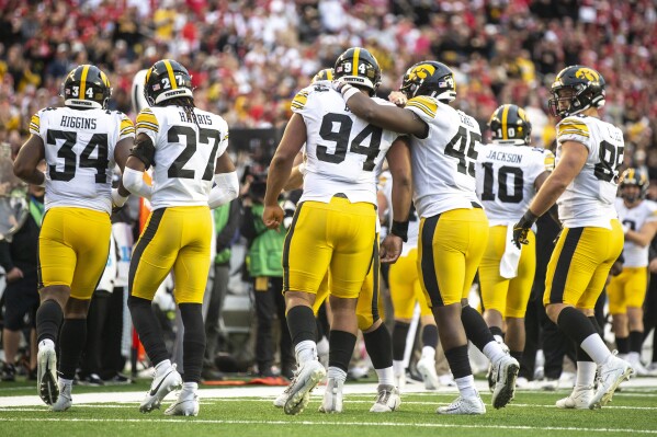 Iowa defensive lineman Yahya Black (94) is swarmed by teammates after forcing a safety during an NCAA college football game against Wisconsin, Saturday, Oct. 14, 2023, in Madison, Wis. (Geoff Stellfox/The Gazette Via AP)
