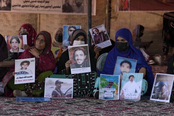 Baloch activists hold portraits of their missing family members during their sit-in protest, in Islamabad, Pakistan Monday, Dec. 25, 2023. Pakistani police say they have freed 290 Baloch activists who were arrested when they attempted to hold a protest rally last week in the capital, Islamabad. Their release Monday came after protest organizers gave authorities a three-day deadline to free all those detained. The activists had travelled from Baluchistan province to protest forced disappearances and extrajudicial killings in the militancy-ravaged southwest. (AP Photo/Anjum Naveed)