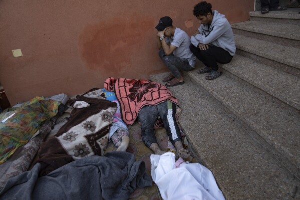 Palestinians mourn relatives killed in the Israeli bombardment of the Gaza Strip in a morgue in Khan Younis, Tuesday, Oct. 17, 2023. (AP Photo/Fatima Shbair)