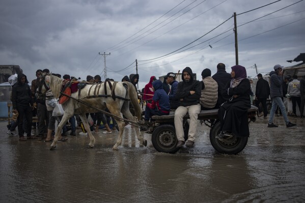 Palestinians displaced by the Israeli air and ground offensive on the Gaza Strip ride on a cart in Rafah, Saturday, Jan. 27, 2024. (AP Photo/Fatima Shbair)