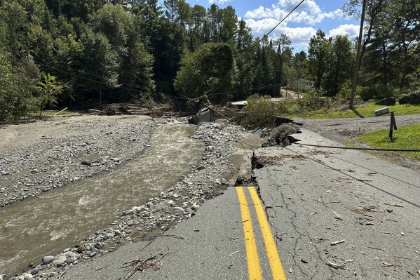 A washed out road and bridge in Lyndon, Vt. is shown Wednesday, Aug. 7, 2024, more than a week after storms caused flooding. (AP Photo/ Lisa Rathke)