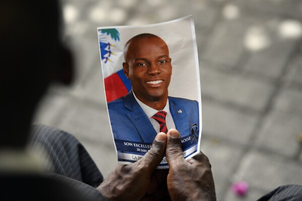 FILE - A person holds a photo of late Haitian President Jovenel Moise during his memorial ceremony at the National Pantheon Museum in Port-au-Prince, Haiti, July 20, 2021. A federal judge in Miami on Tuesday, Dec. 19, 2023, sentenced a former Haitian senator John Joel Joseph to life in prison for conspiring to kill Haiti’s President Moïse in 2021, which caused unprecedented turmoil in the Caribbean nation. (AP Photo/Matias Delacroix, File)
