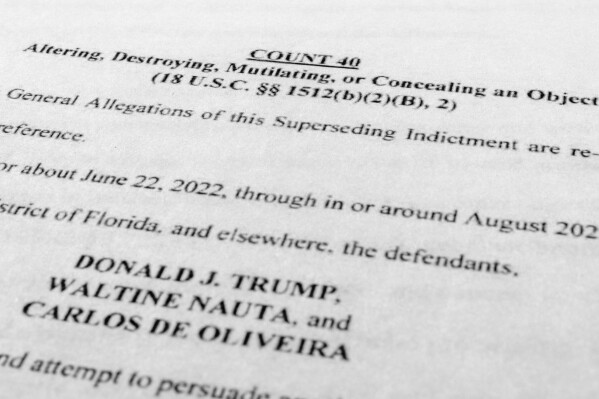 The updated indictment against former President Donald Trump, Walt Nauta and Carlos De Oliveira is photographed Thursday, July 27, 2023. Trump is facing accusations that he and aides asked a staffer to delete camera footage at his Florida estate in an effort to obstruct the classified documents investigations. The allegations were made Thursday in an updated grand jury indictment that adds new charges against Trump and adds another defendant to the case. (AP Photo/Jon Elswick)