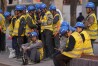 Workers wait for transport outside a construction site in Beijing, Tuesday, April 9, 2024. China's Finance Ministry has denounced a report by Fitch Ratings that kept its sovereign debt rated at A+ but downgraded its outlook to negative, saying in a statement that China's deficit is at a moderate and reasonable level and risks are under control. (AP Photo/Ng Han Guan)