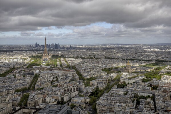 The Eiffel Tower and the Champs-de-Mars at its feet, the Invalides monument and its dome, right, are seen Monday, April 15, 2024 in Paris. The Champ-de-Mars will host the Beach Volleyball and Blind Football and the Invalides will host the Cycling road, Archery and Athetics events at the Paris 2024 Olympic and Paralympic Games. (AP Photo/Aurelien Morissard, File)