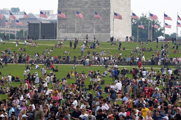 People on the lawn around the Washington Monument as President Donald Trump attends a military parade commemorating the Army's 250th anniversary, coinciding with his 79th birthday, Saturday, June 14, 2025, in Washington. (AP Photo/Julia Demaree Nikhinson)