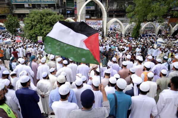 A man waves a Palestinian flag during a protest after Friday prayers in Dhaka, Bangladesh, Friday, April 22, 2022. Thousands of Muslims staged a rally against the planned Quran burnings by a right-wing group in Sweden, and to show solidarity for the Palestinian people following their recent clashes with Israeli police at Al-Aqsa Mosque. (AP Photo/Mahmud Hossain Opu)
