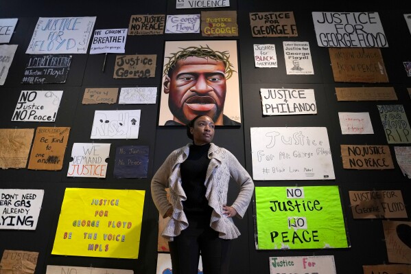 Jeanelle Austin, director of the George Floyd Global Memorial, pauses during the installation of "Twin Flames: The George Floyd Uprising from Minneapolis to Phoenix," at Arizona State University Art Museum, Friday, Jan. 12, 2024, in Tempe, Ariz. For months after George Floyd was killed by police in May 2020, people from around the world traveled to the site of his murder in Minneapolis and left signs, paintings and poems to memorialize the man whose death reignited a movement against systemic racism. Now hundreds of those artifacts are being displayed at an exhibit at the Arizona State University Art Museum. (AP Photo/Ross D. Franklin)