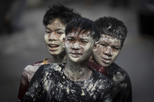 Young men don a powdery paste called din sor pong believed to bring blessings and protection as they take part in the Songkran water festival marking the Thai New Year in the Prachinburi province of central Thailand, April 13, 2025. (AP Photo/Wason Wanichakorn)