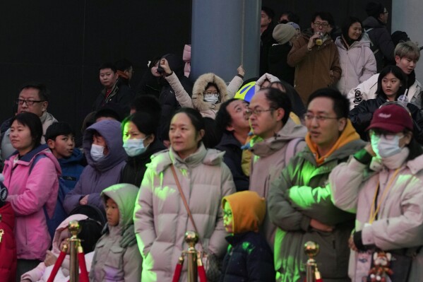 Một đứa trẻ, ở giữa, phản ứng trong đám đông tại một trung tâm mua sắm ở Bắc Kinh vào ngày 30 tháng 12 năm 2023. Dân số Trung Quốc giảm 2 triệu người vào năm 2023, mức giảm hàng năm thứ hai liên tiếp khi tỷ lệ sinh giảm và tỷ lệ tử vong tăng vọt.  (Ảnh AP/Ng Han Guan)