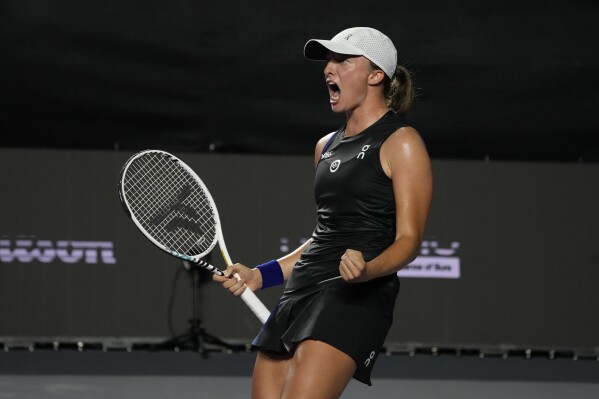 Iga Swiatek, of Poland, celebrates after defeating Aryna Sabalenka, of Belarus, during a women's singles semifinal match at the WTA Finals tennis championships, in Cancun , Mexico, Sunday, Nov. 5, 2023. (AP Photo/Fernando Llano)