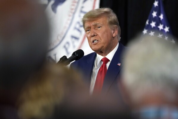 FILE - Former President Donald Trump visits with campaign volunteers at the Elks Lodge, July 18, 2023, in Cedar Rapids, Iowa. A federal judge in Florida has set a trial date for next May for former President Donald Trump in a case charging him with illegally retaining hundreds of classified documents. The May 20, 2024, trial date was set Friday by U.S. District Judge Aileen Cannon. (AP Photo/Charlie Neibergall, File)