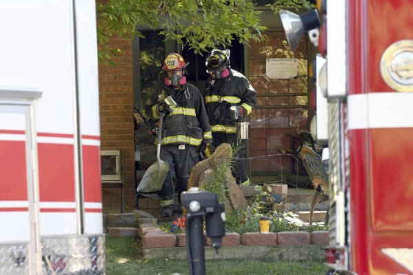 Firefighters walk out of a fire-damaged home in Aurora, Colo., on Thursday, Sept. 21, 2023. The blaze, which happened late Wednesday night, killed two children and injured seven other people. (AP Photo/Thomas Peipert)