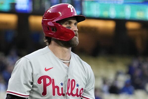 Philadelphia Phillies' Bryce Harper walks back to the dugout after striking out during the first inning of a baseball game against the Los Angeles Dodgers Tuesday, May 2, 2023, in Los Angeles. (AP Photo/Mark J. Terrill)